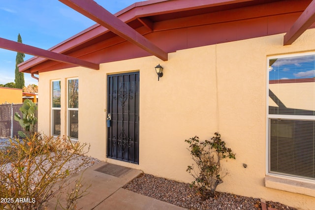 view of exterior entry featuring stucco siding