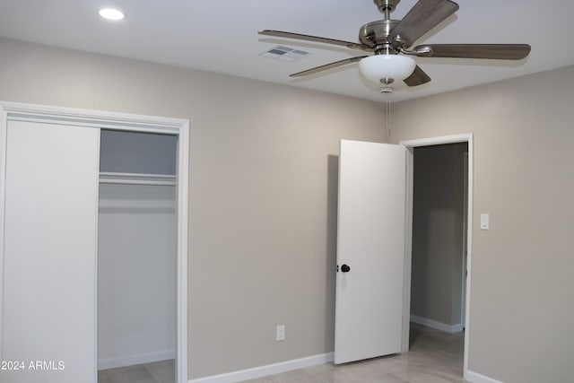 unfurnished bedroom with ceiling fan and a closet