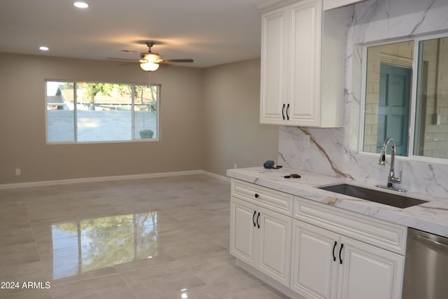 kitchen with white cabinetry, sink, light stone countertops, ceiling fan, and stainless steel dishwasher