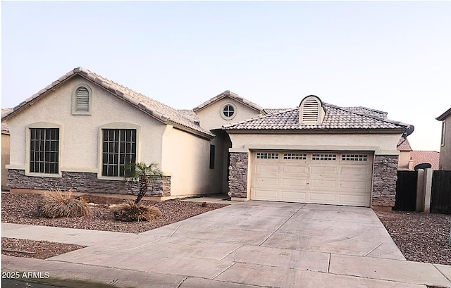 10413 W Roanoke Ave, Avondale, AZ 85392 - view of front of property with stone siding, concrete driveway, and an attached garage