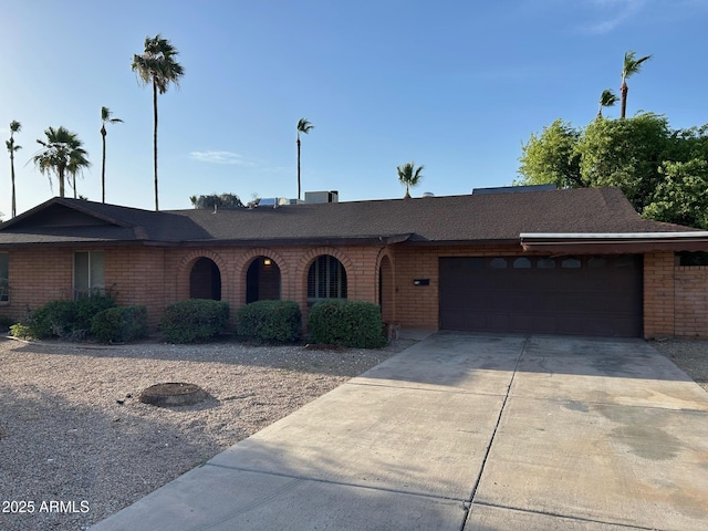 3740 E Mercer Ln, Phoenix, AZ 85028 - ranch-style house featuring brick siding, an attached garage, concrete driveway, and roof with shingles