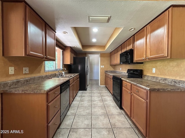 3740 E Mercer Ln, Phoenix, AZ 85028 - kitchen with black appliances, a tray ceiling, dark countertops, light tile patterned flooring, and brown cabinets