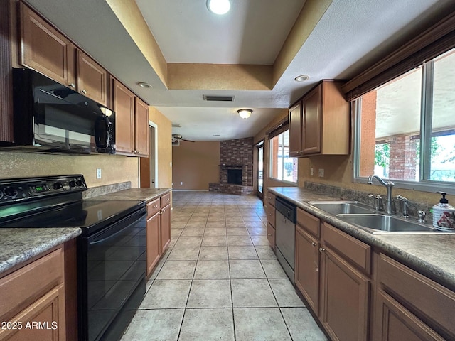 3740 E Mercer Ln, Phoenix, AZ 85028 - kitchen featuring black appliances, a brick fireplace, a tray ceiling, light tile patterned flooring, and open floor plan