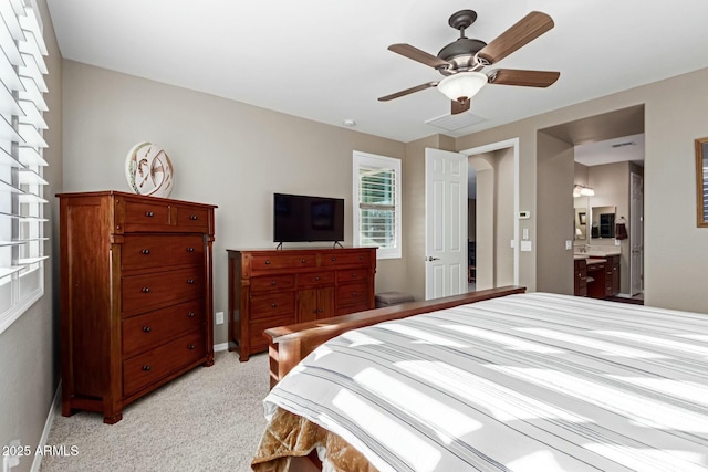 carpeted bedroom featuring ensuite bath and ceiling fan