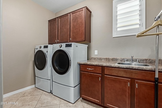 laundry area featuring light tile patterned flooring, cabinets, separate washer and dryer, and sink