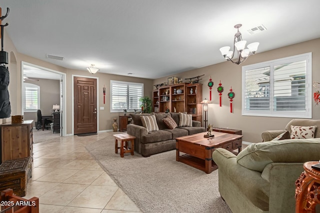 tiled living room featuring ceiling fan with notable chandelier and a wealth of natural light