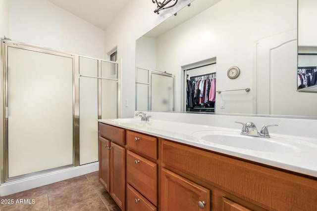 bathroom featuring a shower with door, vanity, and tile patterned flooring