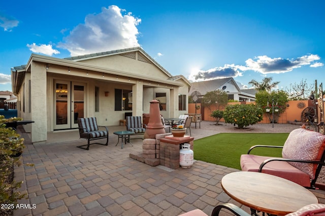 back of property featuring a patio area and a lawn