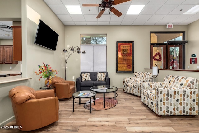 living room featuring ceiling fan, a paneled ceiling, and light hardwood / wood-style flooring