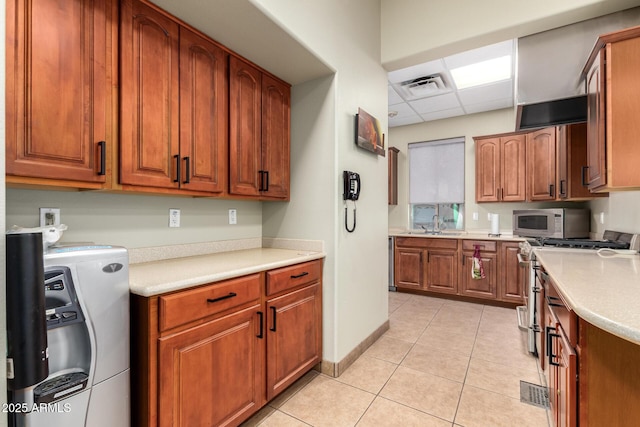 kitchen with light tile patterned flooring, sink, stainless steel appliances, washer / clothes dryer, and a drop ceiling