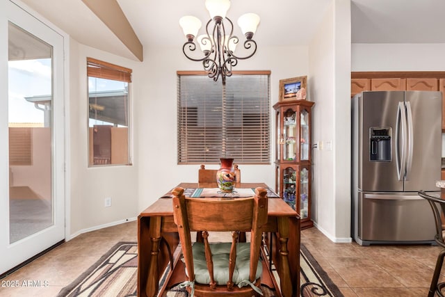 dining space with light tile patterned flooring, a chandelier, and vaulted ceiling