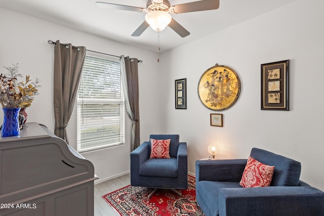 sitting room featuring ceiling fan, baseboards, and light wood-style floors