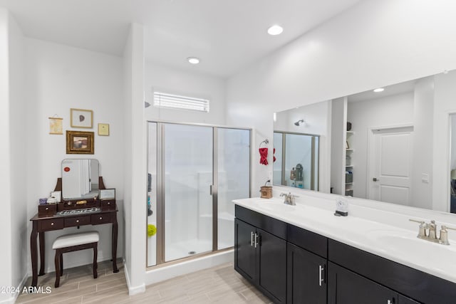 full bath with double vanity, recessed lighting, a shower stall, and a sink