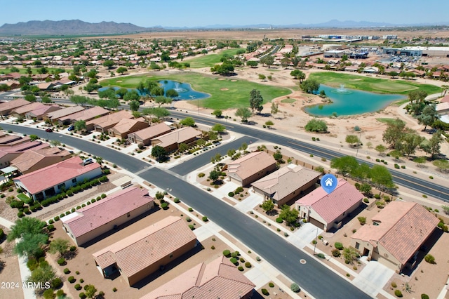 drone / aerial view with view of golf course, a residential view, and a water and mountain view