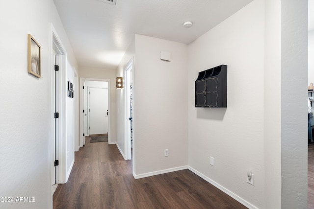 corridor with dark hardwood / wood-style flooring