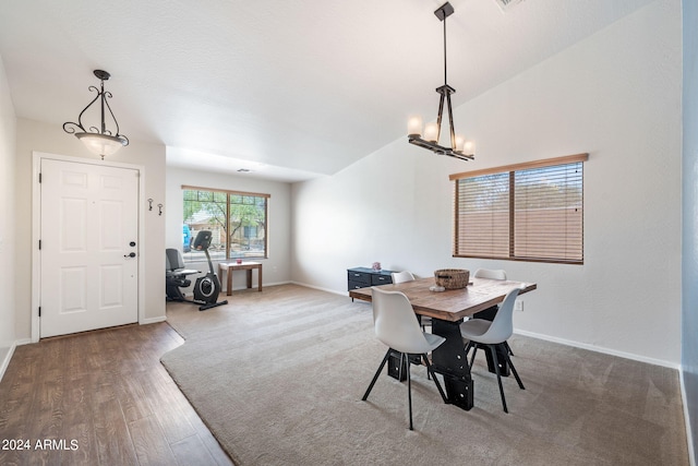 dining area featuring an inviting chandelier, lofted ceiling, and wood-type flooring