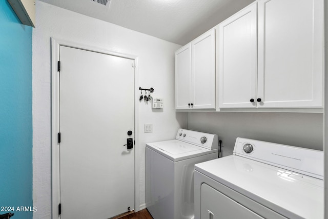 laundry room with cabinets and washer and clothes dryer