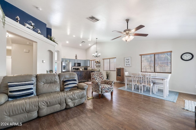 living room featuring hardwood / wood-style flooring, ceiling fan with notable chandelier, and high vaulted ceiling