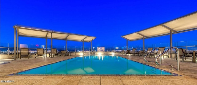 pool at twilight featuring a patio area