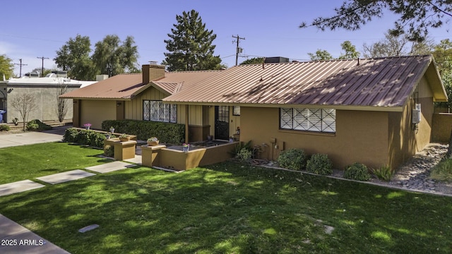 ranch-style house featuring driveway, a chimney, metal roof, an attached garage, and a front lawn