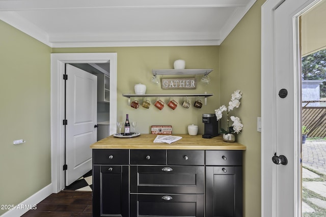 bar with ornamental molding, baseboards, a dry bar, and dark wood-style floors