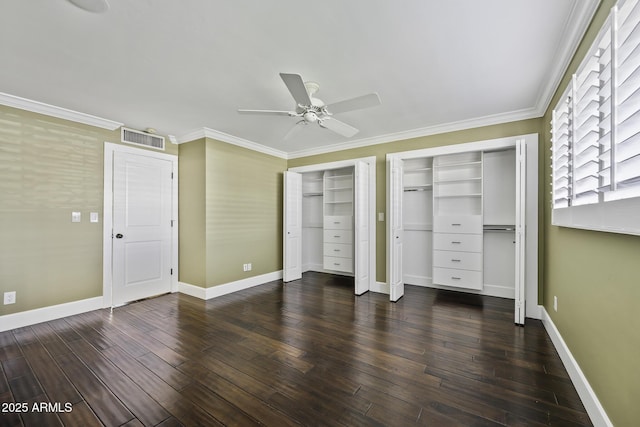 unfurnished bedroom featuring two closets, wood finished floors, visible vents, and baseboards