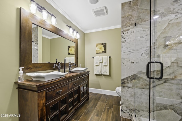 bathroom with a stall shower, visible vents, ornamental molding, wood tiled floor, and a sink