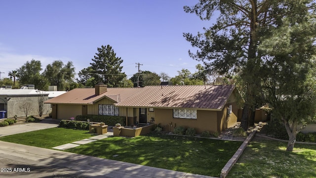 ranch-style house featuring driveway, a chimney, metal roof, and a front yard