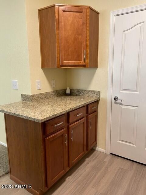 kitchen featuring light hardwood / wood-style flooring and light stone counters