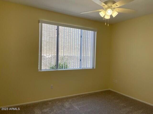 empty room featuring carpet floors and ceiling fan