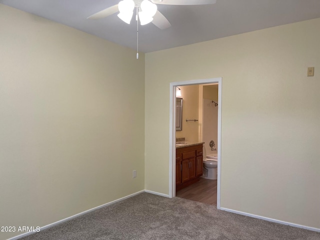 unfurnished bedroom featuring light colored carpet, ceiling fan, and ensuite bathroom