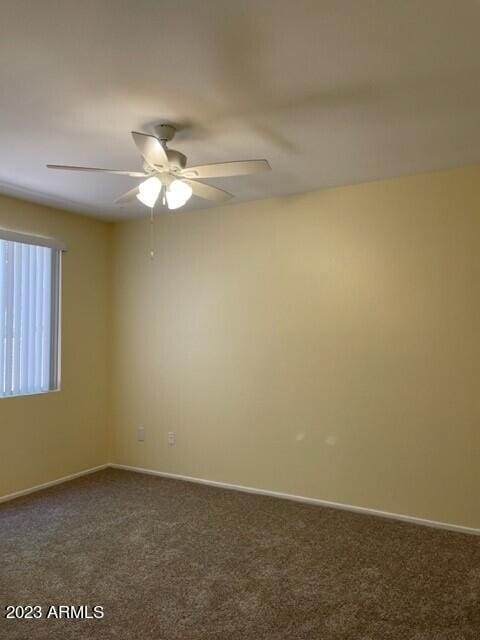 carpeted spare room featuring ceiling fan