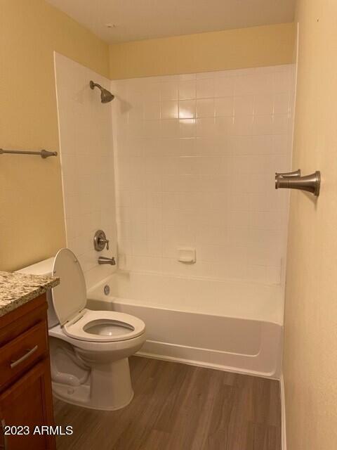 full bathroom with wood-type flooring, toilet, vanity, and tiled shower / bath