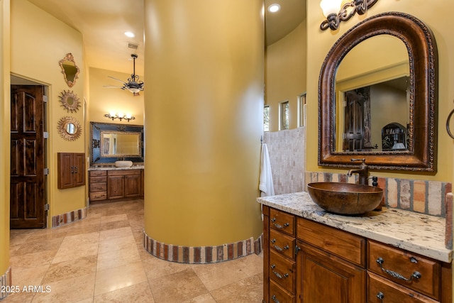 bathroom with baseboards, a towering ceiling, and vanity