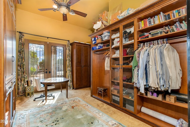 spacious closet featuring light carpet, french doors, and ceiling fan