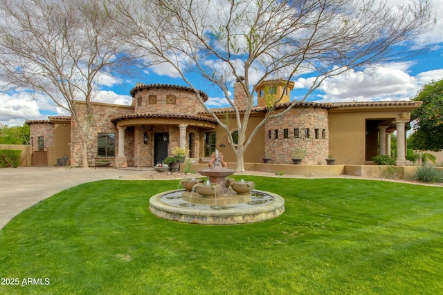 exterior space with a tiled roof, a front yard, stucco siding, a chimney, and stone siding