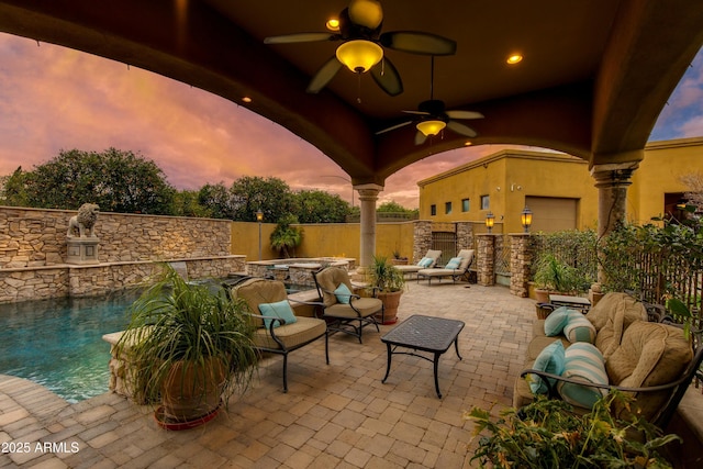 view of patio with a ceiling fan, an outdoor living space, a fenced backyard, and a hot tub