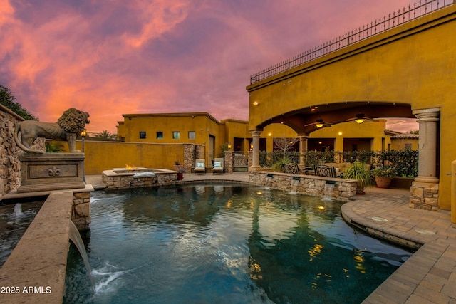 view of swimming pool featuring a patio, a pool with connected hot tub, ceiling fan, and fence