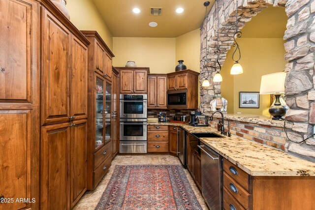 kitchen featuring a sink, visible vents, brown cabinets, and stainless steel appliances