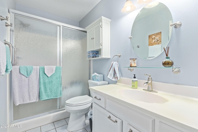 bathroom featuring toilet, tile patterned flooring, a shower with shower door, and vanity