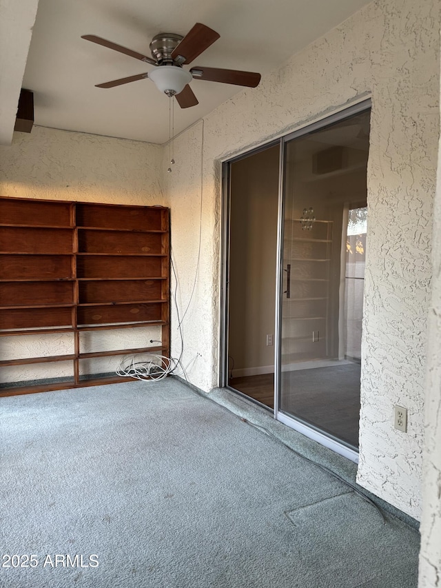 carpeted empty room featuring ceiling fan