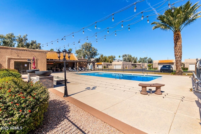 community pool featuring a patio and fence