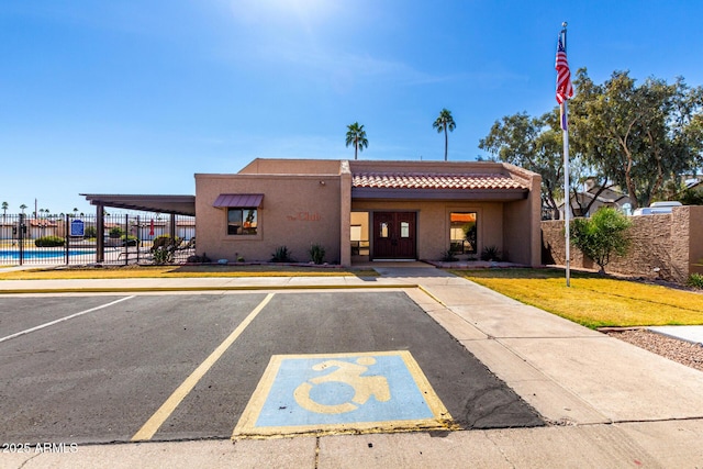 view of building exterior with uncovered parking and fence