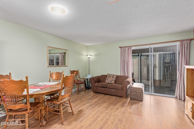 dining space featuring a textured ceiling and light wood-type flooring