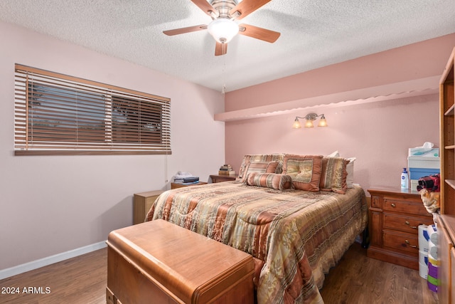 bedroom with ceiling fan, a textured ceiling, baseboards, and wood finished floors