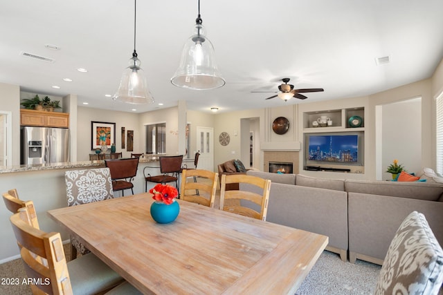 carpeted dining room with ceiling fan