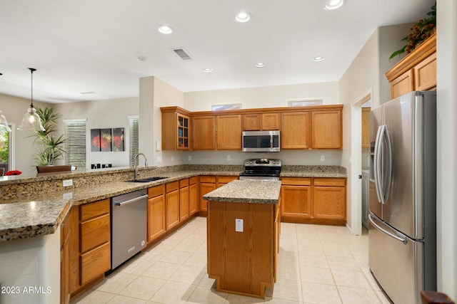 kitchen featuring sink, hanging light fixtures, kitchen peninsula, a kitchen island, and appliances with stainless steel finishes