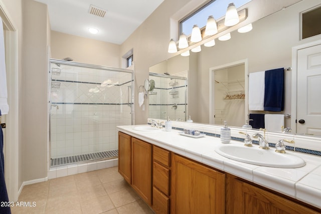 bathroom with tile patterned flooring, vanity, and a shower with shower door