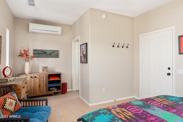 bedroom with light tile patterned floors and an AC wall unit