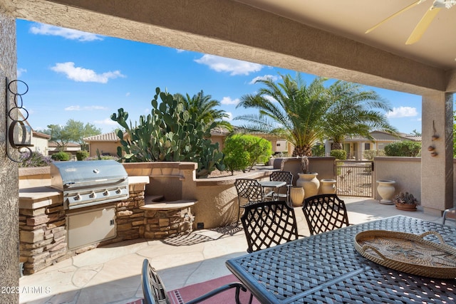 view of patio / terrace with grilling area, ceiling fan, and exterior kitchen